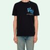 Camiseta con estampado de flechas verdes sobre una valla, manga corta, color negro