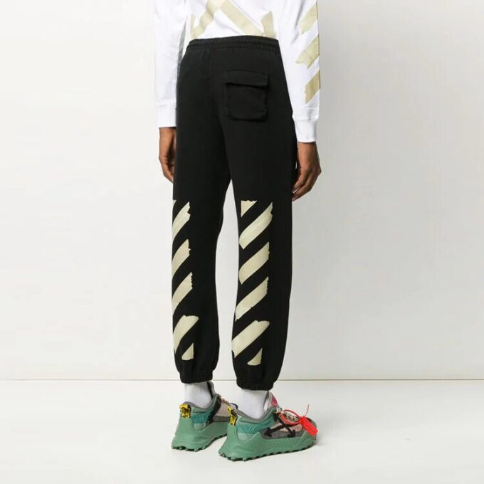 Pantalones deportivos negros con rayas y correa de goma en negro y dorado